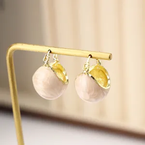 Vintage drop glaze hoop earrings with cream enamel finish on gold display stand