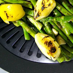 Primer plano de espárragos y limón a la parrilla en una placa de barbacoa negra