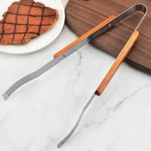Close-up of professional stainless steel BBQ tongs with heat-resistant wooden handles