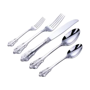 Detail of vintage silver cutlery set with ornate royal palace style embossed handles