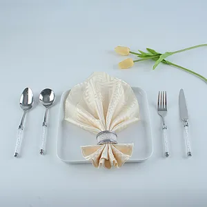 Crystal rhinestone napkin ring detail, elegant table setting with silverware and decorative floral.