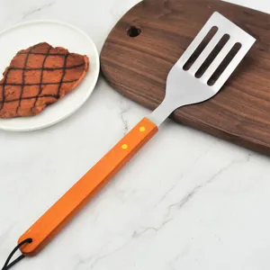 Professional stainless steel BBQ spatula with long wooden handle on marble surface