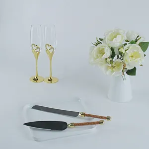 Detailansicht von Hochzeits-Sektgläsern und Tortenheber-Set, elegante goldene Griffe.