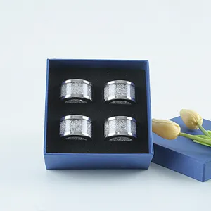 Set of 4 silver crystal napkin rings closeup view in blue gift box with yellow tulips.