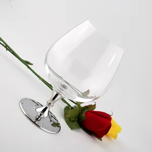 Detailansicht eines Kristall-Brandyglases mit elegantem Metallfuß und Rosen-Deko