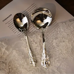 Close-up of vintage silver-plated spoons with intricate royal engravings