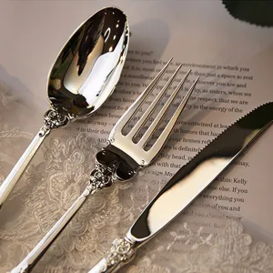 Detailed view of elegant vintage silver-plated cutlery with intricate floral engravings