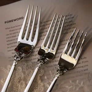 Close-up of ornate patterns on vintage silver-plated stainless steel dinner forks