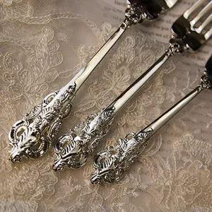 Close-up of elegant vintage ornate silver-plated cutlery handles resting on white lace