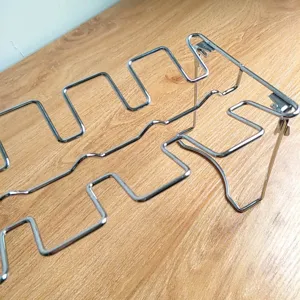 Close-up of folding stainless steel chicken leg rack with wave slots for BBQ.