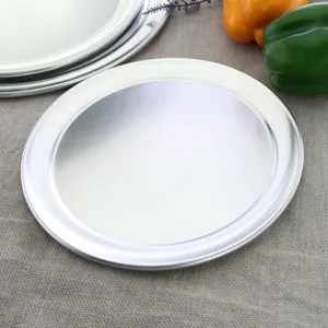 Draufsicht auf eine runde Pizzapfanne aus Aluminium mit breitem Rand auf Leinen