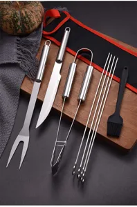 Detail of 8-piece stainless steel BBQ tool set displayed on a wooden board