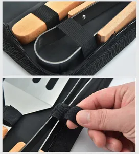 Close-up of wooden handle BBQ tools secured by velcro strap in black bag