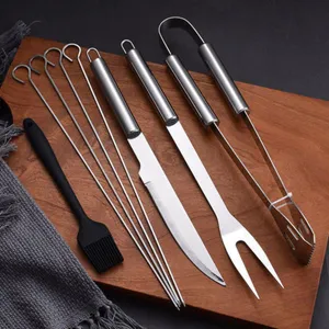 Professional stainless steel BBQ tool set with knife, fork, tongs, brush, and skewers
