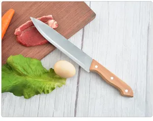 Stainless steel kitchen knife with wooden handle shown on a wooden cutting board with food