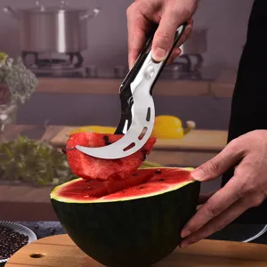 Stainless steel watermelon slicer tool picking up a fresh fruit slice in a kitchen
