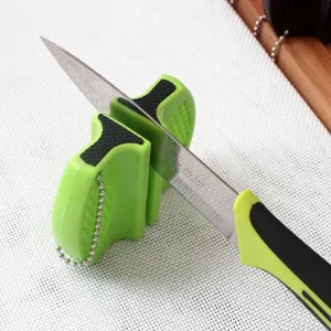 Action detail of a portable mini green knife sharpener for quick kitchen blade sharpening
