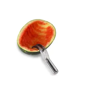 Close-up of stainless steel watermelon slicer cutting fruit inside a melon rind