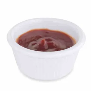 Small white ceramic sauce bowl filled with red tomato ketchup for dipping fries