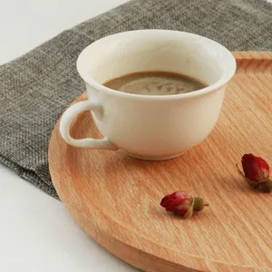 Primer plano de bandeja de madera de haya con taza de café y rosas.