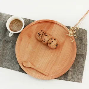 Vista superior de una bandeja redonda de madera de haya con galletas y una cuchara de madera