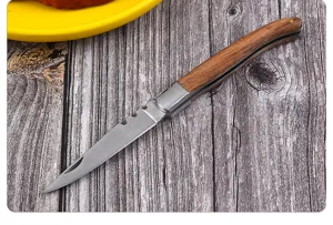 Detail van Laguiole stijl zakmes met rustiek houten handvat op houten oppervlak