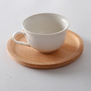 Bandeja redonda minimalista de madera de haya con una taza de café de cerámica blanca limpia