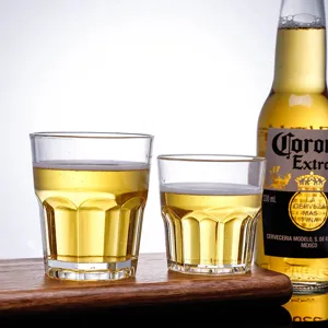 Macro view of two transparent octagonal acrylic beer glasses on a wooden tray