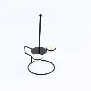 Detail view of black metal onion ring rack tower with two ceramic dipping sauce cups