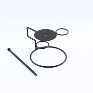Close-up of a black metal wire food presentation stand with rings and a support rod