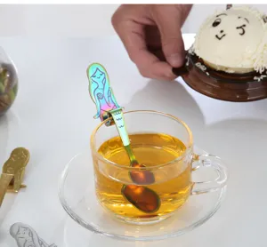 Vue détaillée d'une cuillère sirène arc-en-ciel en inox accrochée au bord d'une tasse