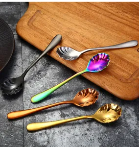 Detailed view of colorful shell-shaped stainless steel dessert spoons on a wood board