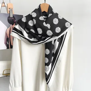 Eleganter quadratischer Seidenschal mit schwarz-weißem Kamelienmuster an weißem Hemd