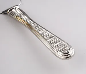 Close-up of a luxury stainless steel cake server handle encrusted with clear crystals