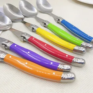 Macro view of colorful stainless steel dessert spoons featuring iconic bee handle motif.