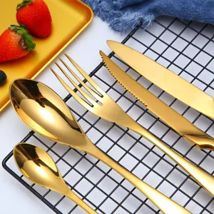 Detailopname van luxe gouden roestvrijstalen bestekset op een zwart metalen rek.