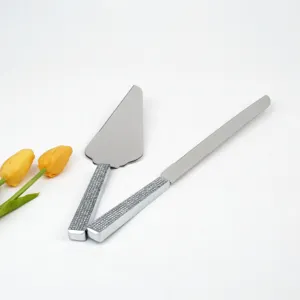 Detalle de cuchillo y pala de tarta de acero inoxidable con mangos de cristal brillante