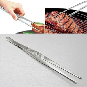 High-quality long stainless steel kitchen tweezers flipping steak on a BBQ outdoor grill