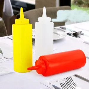 Assortiment de bouteilles à presser en plastique rouge jaune et blanc sur une table de restaurant