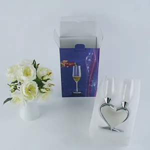 Detail shot of heart shaped crystal champagne glasses set with gift box and white rose decor.