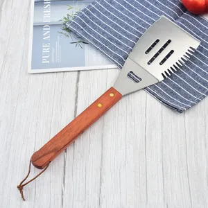 Detail view of a professional BBQ spatula with a durable wooden handle and stainless steel head