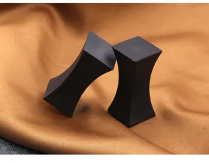 Detailed close-up of matte black alloy chopstick rests placed on elegant golden silk fabric