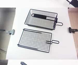 Detail view of non-stick black metal mesh BBQ grill basket and foldable rack