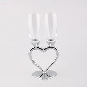 Detailed view of crystal champagne flutes on a silver heart-shaped stand, perfect for weddings.
