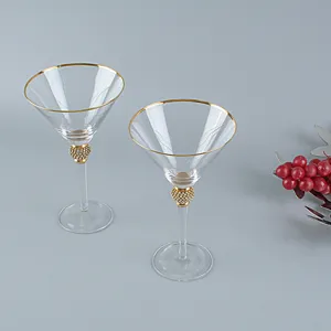 Vista dettagliata di due bicchieri da martini con eleganti bordi dorati e steli con strass.