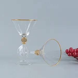 Dettaglio di elegante bicchiere da martini con lussuoso bordo dorato e stelo con strass