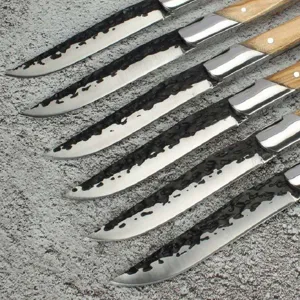 Detalle de cuchillos de carne Laguiole con acabado forjado negro y mango de madera