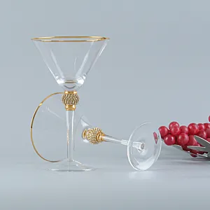 Dettaglio di un bicchiere da martini vintage con bordo dorato e stelo in strass.