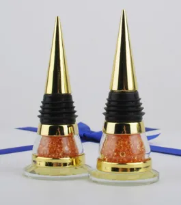 Close-up of golden cone wine stoppers featuring vibrant orange crystal details