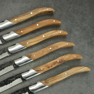 Detalle de cuchillos chuleteros Laguiole con mangos de madera de olivo y hojas negras